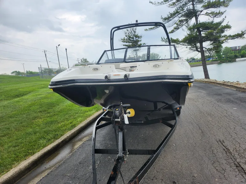 Slide: The Image of 2015 Starcraft Crossover 210 SCX IO boat on trailer near a lake. - 6