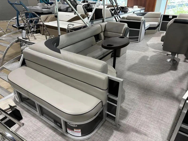 Slide: The Image of 2024 South Bay 200 Series S222CR2 pontoon boat interior with gray seating and table. - 13