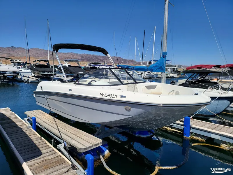 Slide: The Image of 2021 Bayliner E 21 boat docked at a marina with other boats. - 2