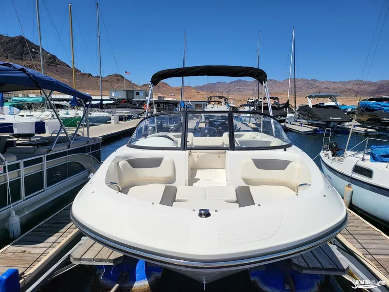 Slide: The Image of 2021 Bayliner E 21 boat docked at a marina with mountains in the background. - 3