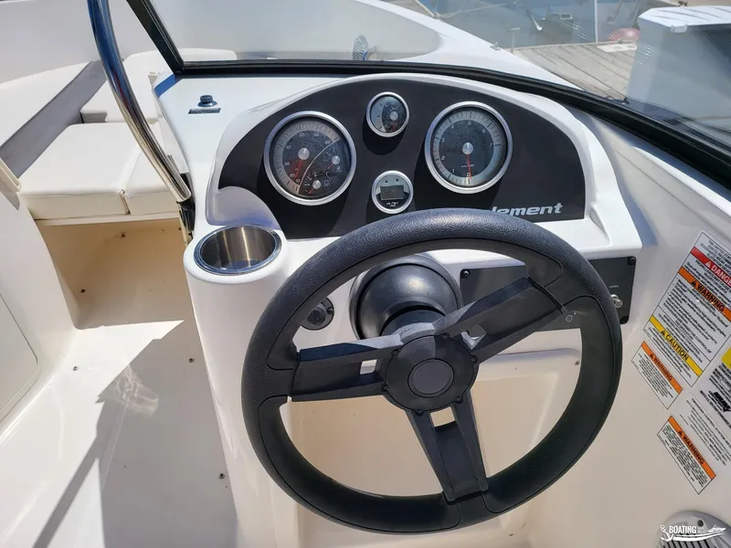 Slide: The Image of 2021 Bayliner E 21 boat dashboard with steering wheel and gauges. - 4
