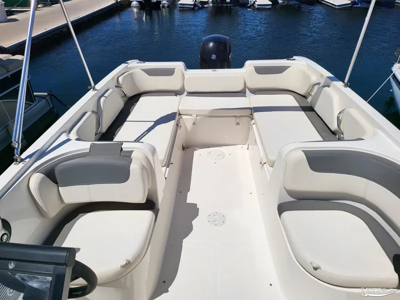 Slide: The Image of 2021 Bayliner E 21 boat interior with spacious seating at a marina. - 6
