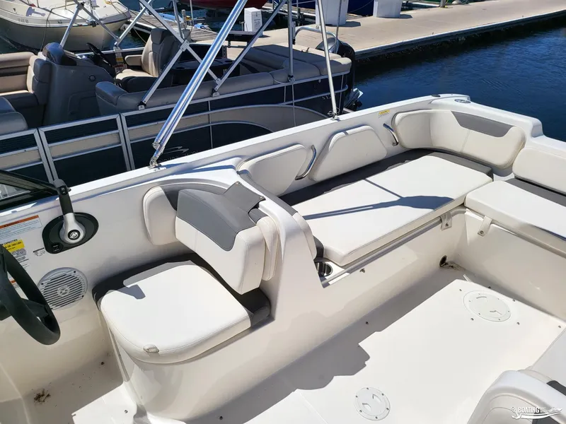 Slide: The Image of 2021 Bayliner E 21 boat interior with white seating and steering wheel. - 9
