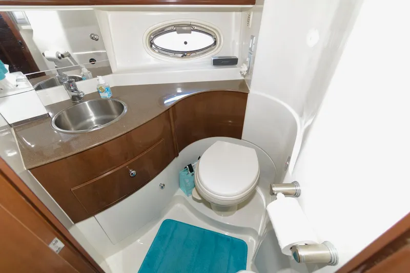 Slide: The Image of 2007 Carver 42 Super Sport yacht bathroom with sink, toilet, and porthole window. - 21