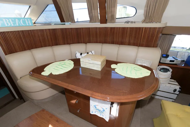 Slide: The Image of Interior dining area of 2007 Carver 42 Super Sport yacht with wooden table and leather seating. - 17