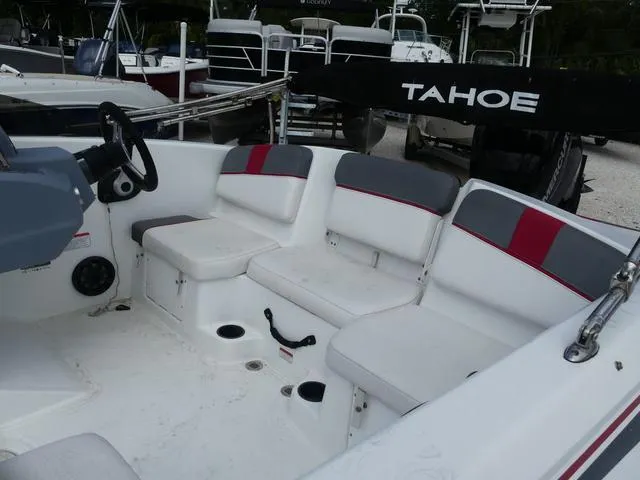 Slide: The Image of 2021 Tahoe T16 boat interior with white and gray seating, steering wheel, and cup holders. - 10