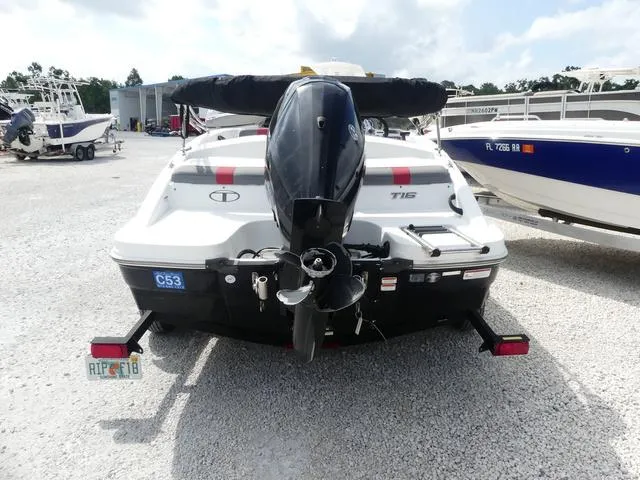 Slide: The Image of 2021 Tahoe T16 boat rear view, parked on gravel, with outboard motor and trailer. - 4