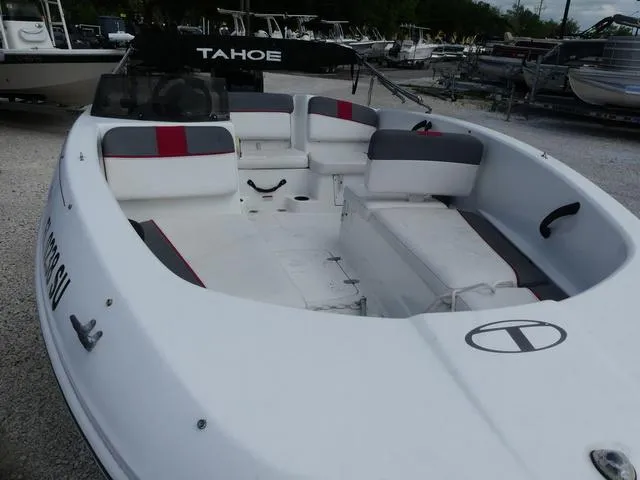 Slide: The Image of 2021 Tahoe T16 boat with spacious seating and sleek design, parked on gravel. - 9