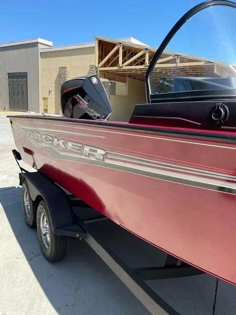 Slide: The Image of 2024 Tracker Targa V-19 WT boat on trailer, parked outdoors, with trees in the background. - 2