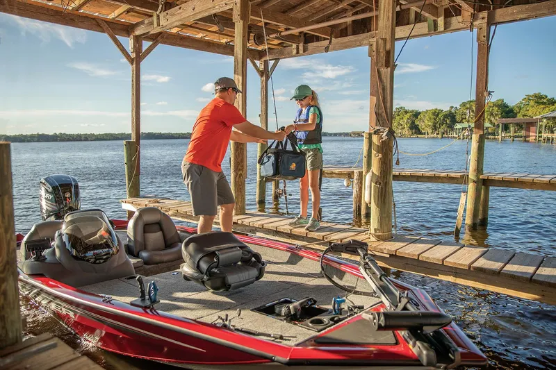Slide: The Image of 2024 Tracker Pro Team 175 TXW boat docked, people loading gear. - 3