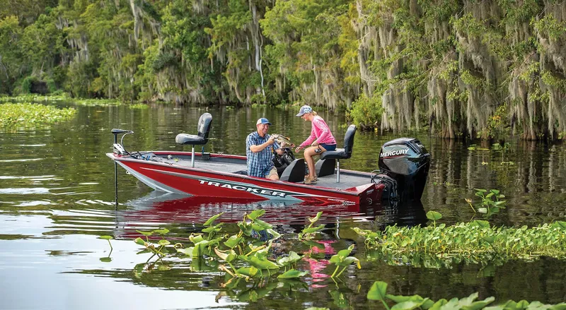 Slide: The Image of 2024 Tracker Pro Team 175 TXW boat on a scenic lake with two people fishing. - 6