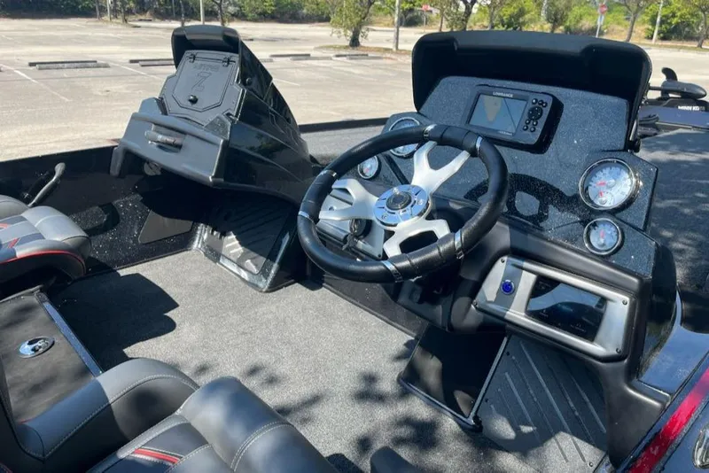 Slide: The Image of 2024 Nitro Z19 boat cockpit with steering wheel, dashboard, and seating. - 2