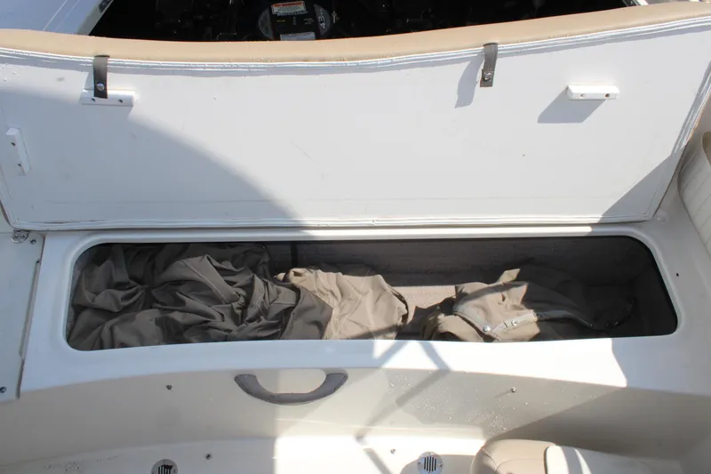 Slide: The Image of Open storage compartment in a 2014 Stingray 198 LF boat, containing fabric items. - 17
