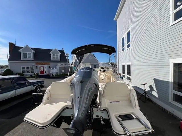 Slide: The Image of 2022 Grady-White Freedom 215 boat docked near buildings under a clear blue sky. - 2