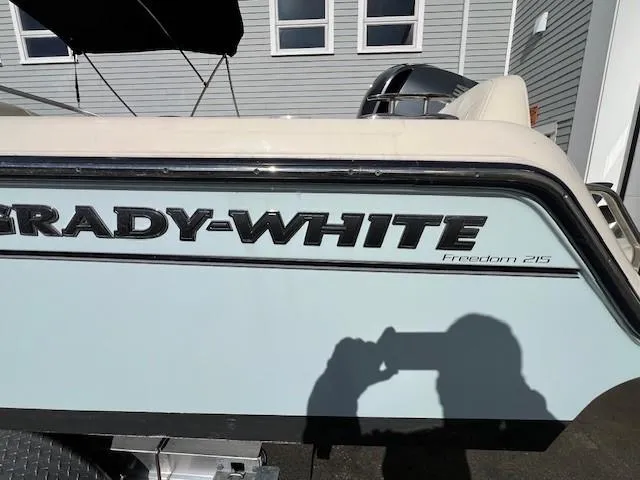 Slide: The Image of 2022 Grady-White Freedom 215 boat side view with logo and shadow. - 4