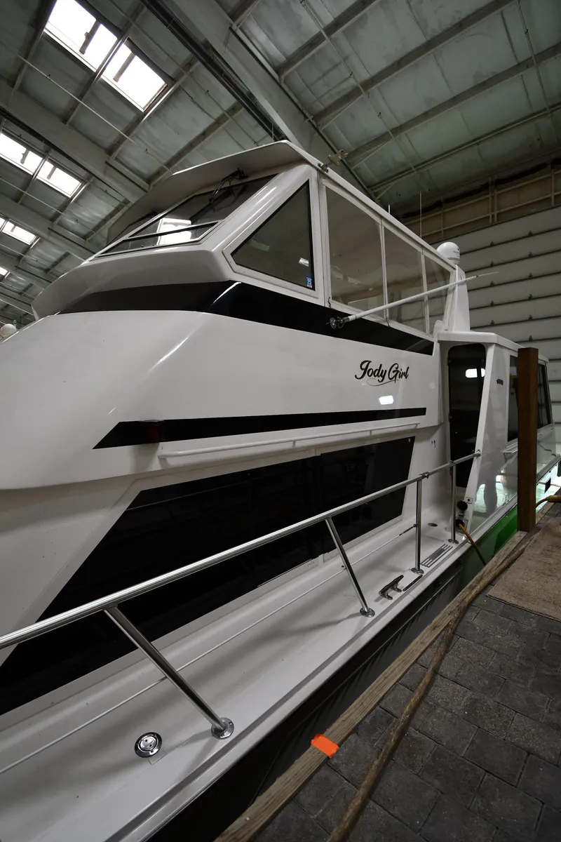 Slide: The Image of 1997 Viking 60 Cockpit Sport Yacht in a boat storage facility. - 12