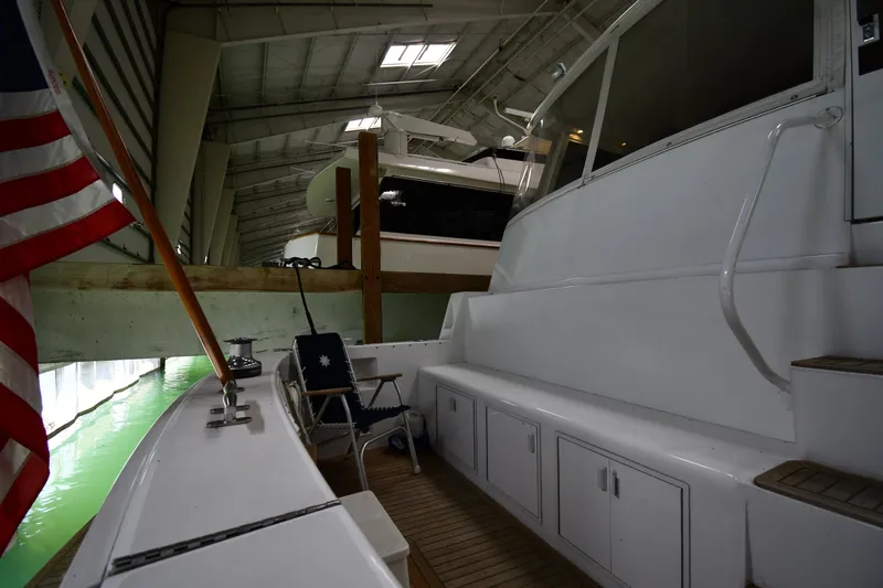 Slide: The Image of 1997 Viking 60 Cockpit Sport Yacht in covered marina, featuring spacious deck and seating area. - 21