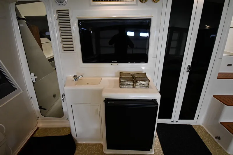 Slide: The Image of 1997 Viking 60 Cockpit Sport Yacht interior with TV, sink, and mini-fridge. - 30