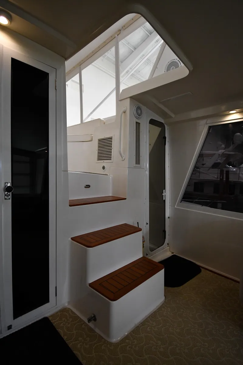 Slide: The Image of Interior stairs of a 1997 Viking 60 Cockpit Sport Yacht with wooden steps. - 33