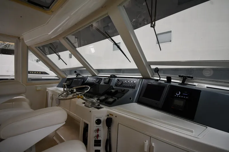 Slide: The Image of 1997 Viking 60 Cockpit Sport Yacht helm with modern navigation equipment and white seating. - 35