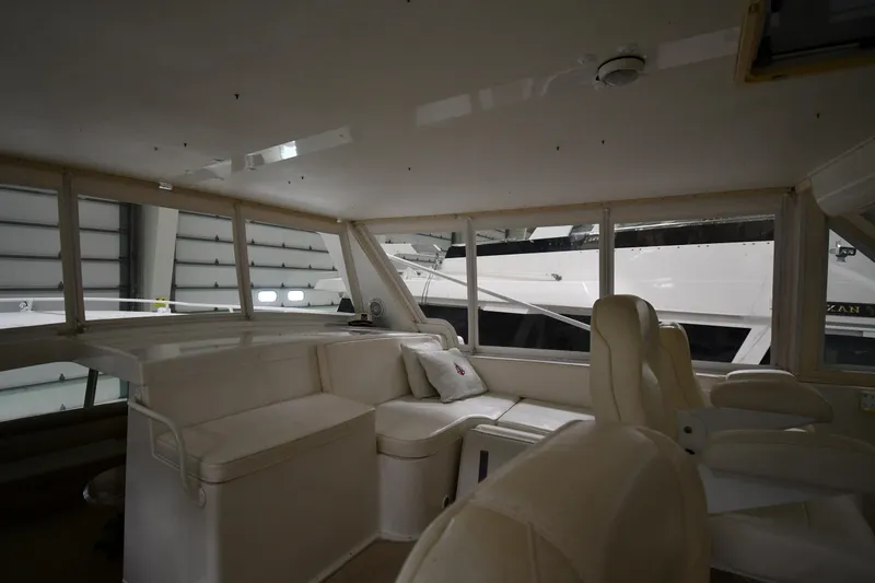 Slide: The Image of Interior of a 1997 Viking 60 Cockpit Sport Yacht with white seating and large windows. - 45