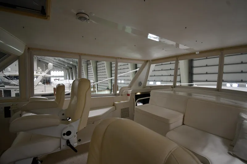 Slide: The Image of Interior of 1997 Viking 60 Cockpit Sport Yacht with white seating and helm chairs. - 46