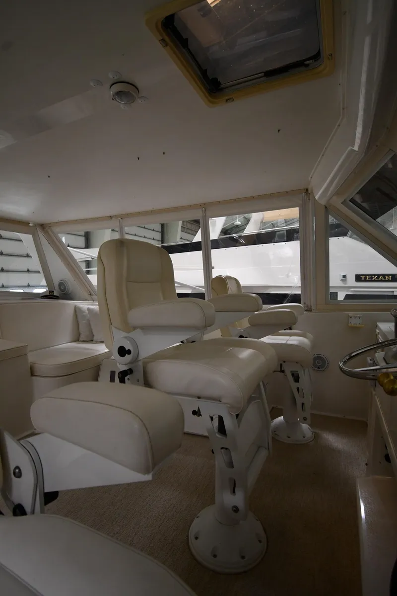 Slide: The Image of Interior of 1997 Viking 60 Cockpit Sport Yacht with white captain chairs. - 47