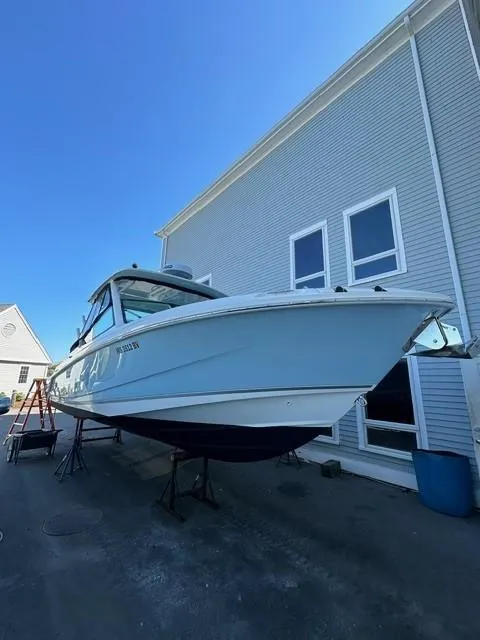 Slide: The Image of 2023 Boston Whaler 280 Vantage boat docked near a building. - 0