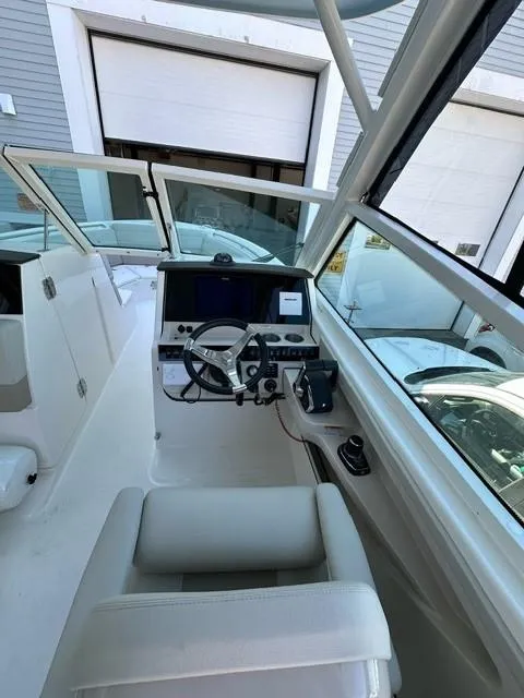Slide: The Image of 2023 Boston Whaler 280 Vantage boat cockpit with steering wheel and control panel. - 10