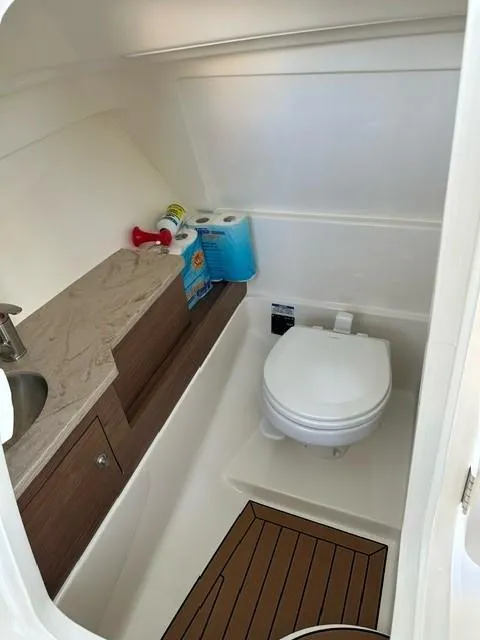 Slide: The Image of 2023 Boston Whaler 280 Vantage boat bathroom with toilet and storage. - 20