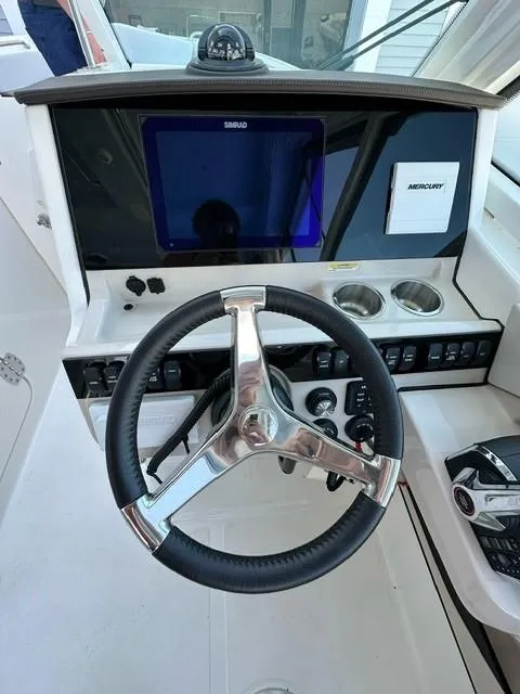 Slide: The Image of Steering console of a 2023 Boston Whaler 280 Vantage boat with modern controls. - 24