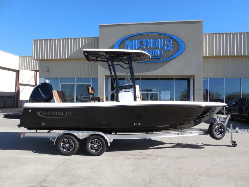 Slide: The Image of 2024 Robalo 226 Cayman boat on trailer outside Nichols Marine dealership. - 1
