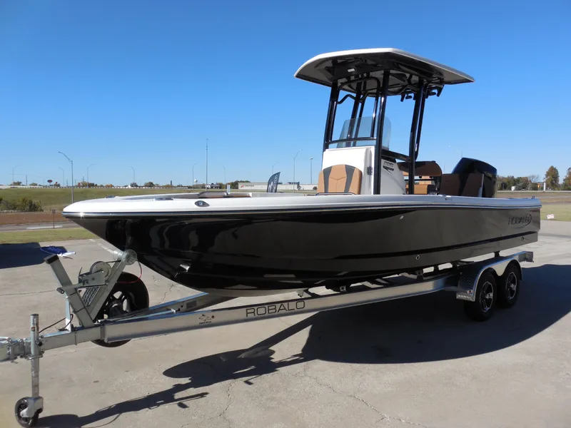 Slide: The Image of 2024 Robalo 226 Cayman boat on trailer, sleek design, black hull, sunny day. - 5
