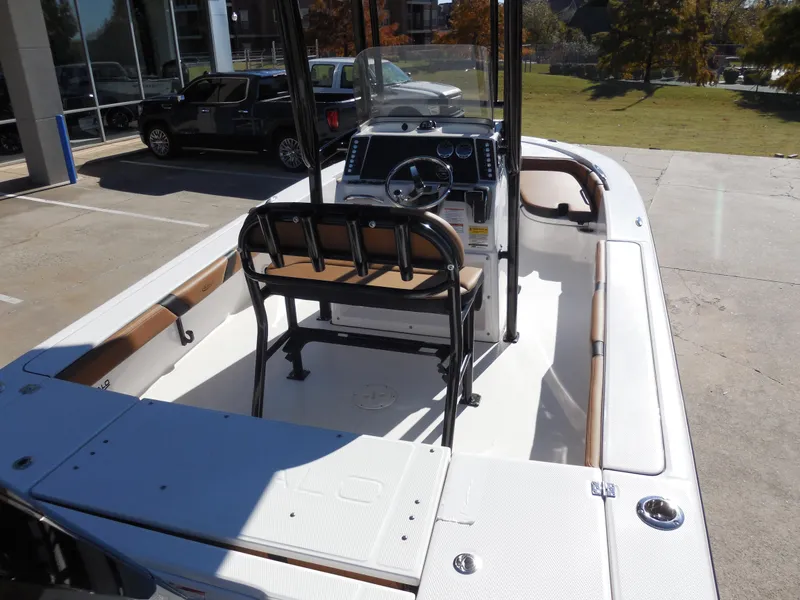 Slide: The Image of 2024 Robalo 226 Cayman boat interior with console and seating, parked outdoors. - 6