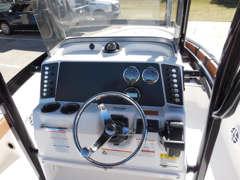 Slide: The Image of 2024 Robalo 226 Cayman boat dashboard with steering wheel and gauges. - 7