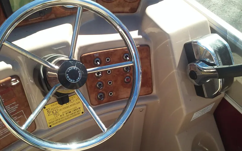 Slide: The Image of Steering wheel and control panel of a 2012 Crest Classic 210 boat. - 18