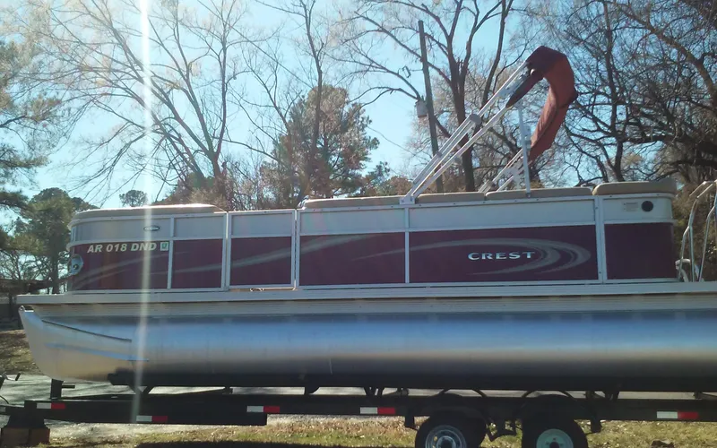 Slide: The Image of 2012 Crest Classic 210 pontoon boat on trailer in outdoor setting. - 4