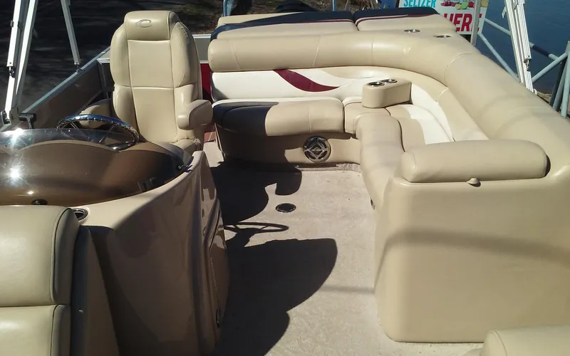Slide: The Image of 2012 Crest Classic 210 boat interior with beige seating and steering console. - 8