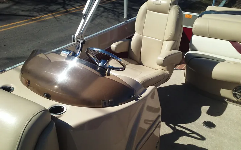 Slide: The Image of 2012 Crest Classic 210 boat interior with beige captain's chair and steering console. - 9
