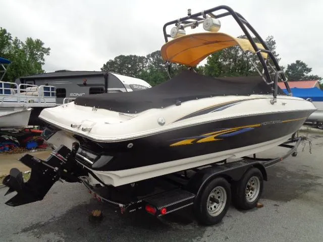Slide: The Image of 2001 Monterey 218LS Montura boat on a trailer, black and white with yellow accents. - 2