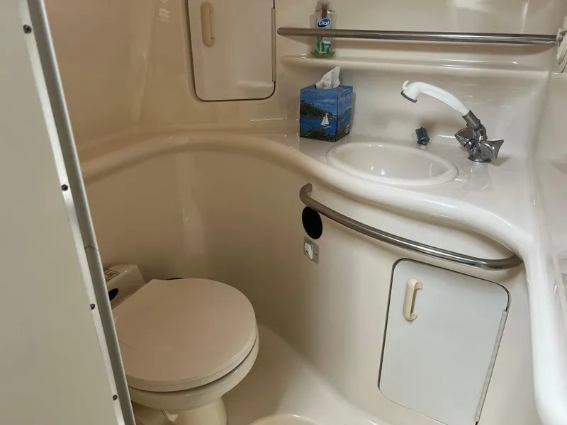 Slide: The Image of 1997 Sea Ray 330 Sundancer bathroom with sink, toilet, and storage cabinets. - 13
