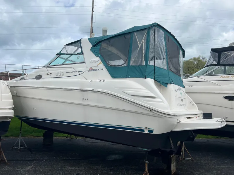 Slide: The Image of 1997 Sea Ray 330 Sundancer boat with green canvas cover on dry dock. - 19