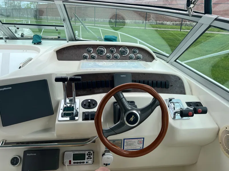 Slide: The Image of 1997 Sea Ray 330 Sundancer helm with steering wheel, controls, and navigation equipment. - 3