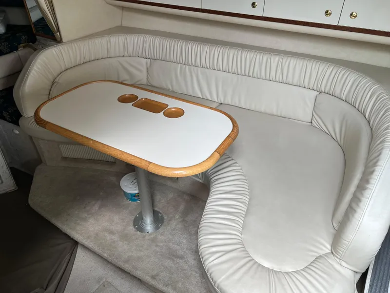 Slide: The Image of 1997 Sea Ray 330 Sundancer interior with white leather seating and dining table. - 6