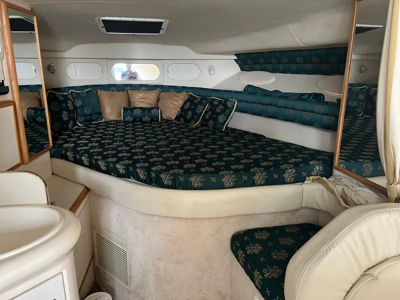 Slide: The Image of Interior cabin of a 1997 Sea Ray 330 Sundancer with patterned bedding and cushions. - 8