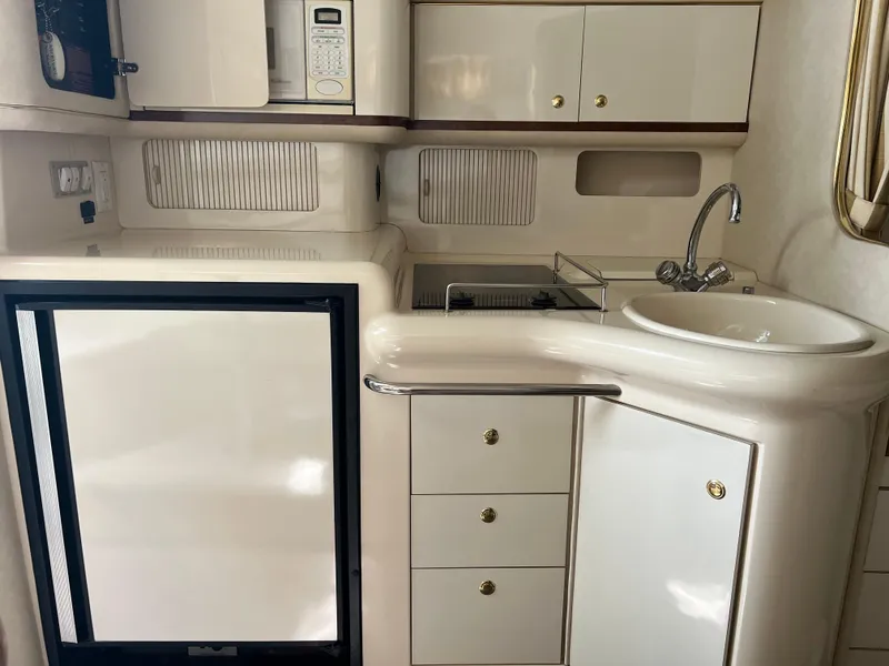 Slide: The Image of 1997 Sea Ray 330 Sundancer galley with sink, microwave, and refrigerator. - 9