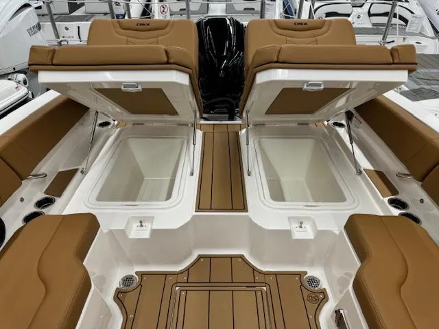 Slide: The Image of 2025 Chaparral 250 OSX boat interior with open storage compartments and tan seating. - 17