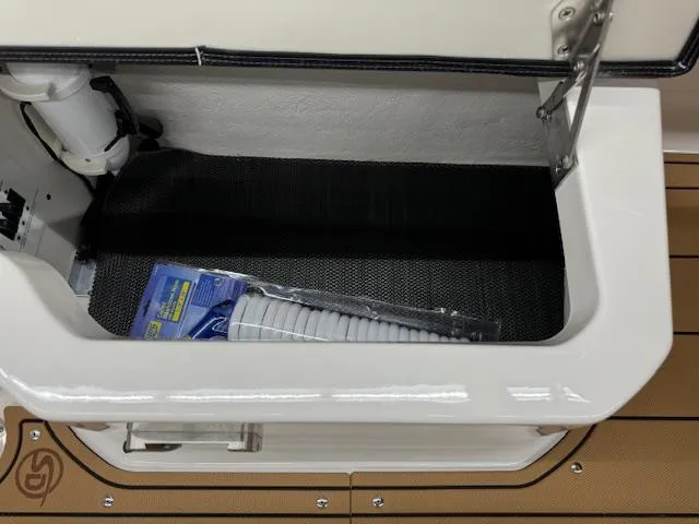 Slide: The Image of Storage compartment in 2025 Chaparral 250 OSX boat with coiled hose. - 21