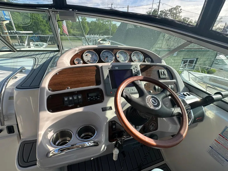 Slide: The Image of 2007 Chaparral 310 Signature boat helm with wood accents and modern controls. - 18