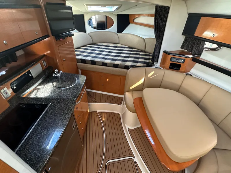 Slide: The Image of 2007 Chaparral 310 Signature yacht interior with kitchen, seating, and bed. - 20